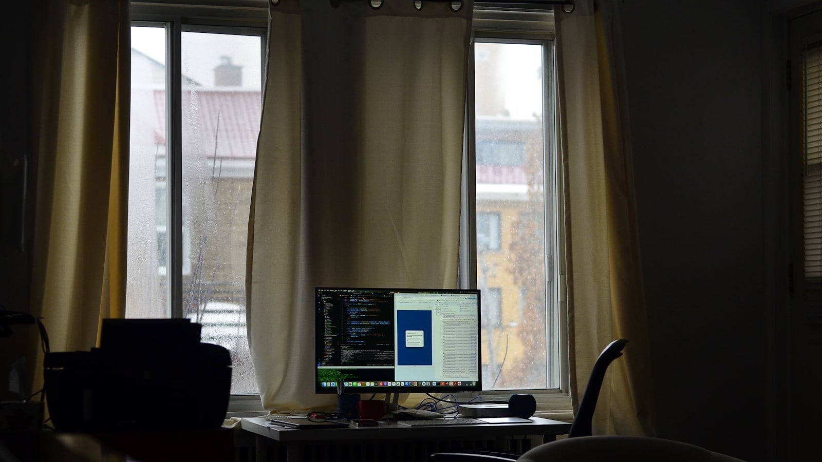 A computer monitor displaying lines of code in a dimly lit room (photo: Joy Real / Unsplash)
