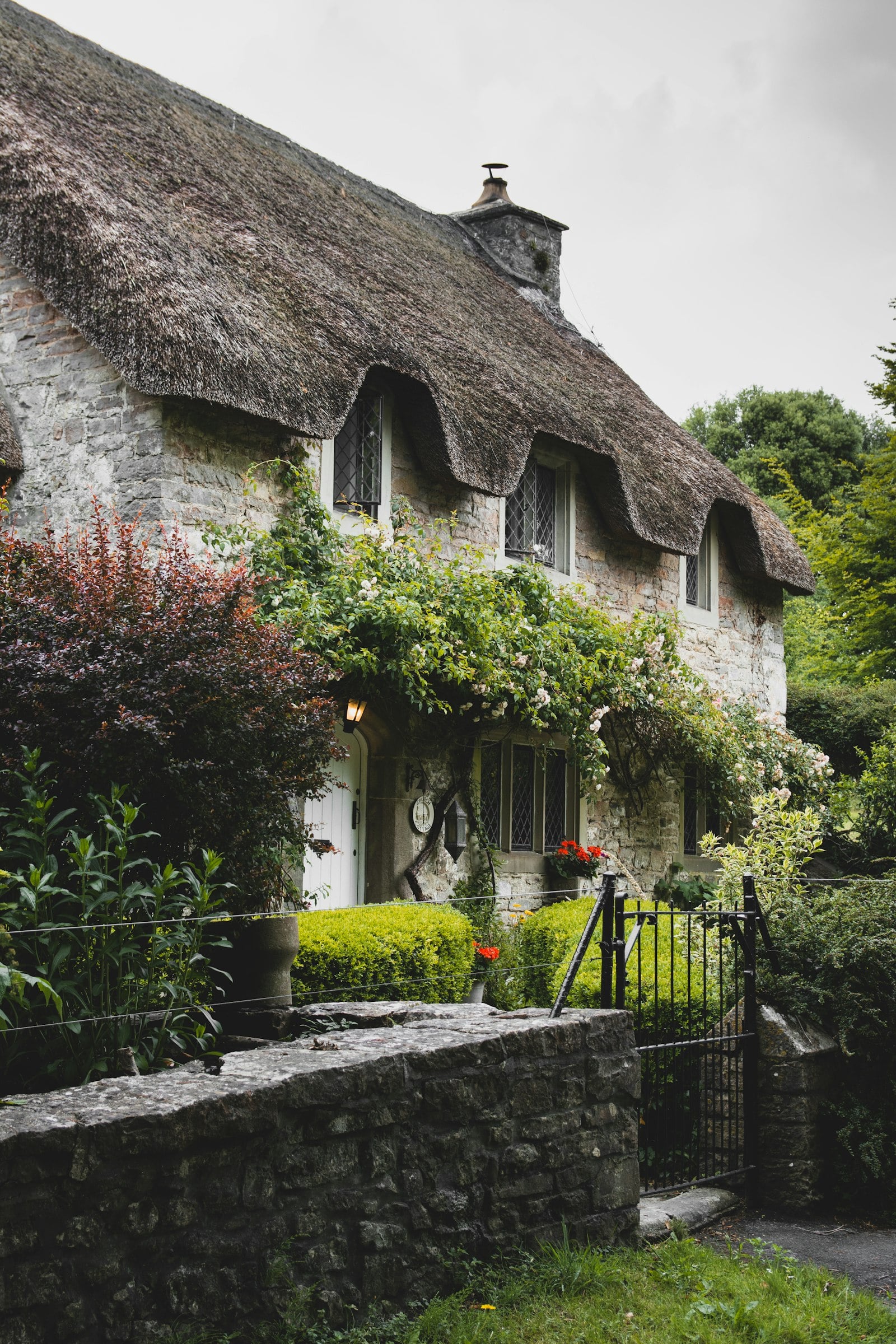 Brick and timber cottages along a country lane with green hills (photo: Charles Lamb / Unsplash)