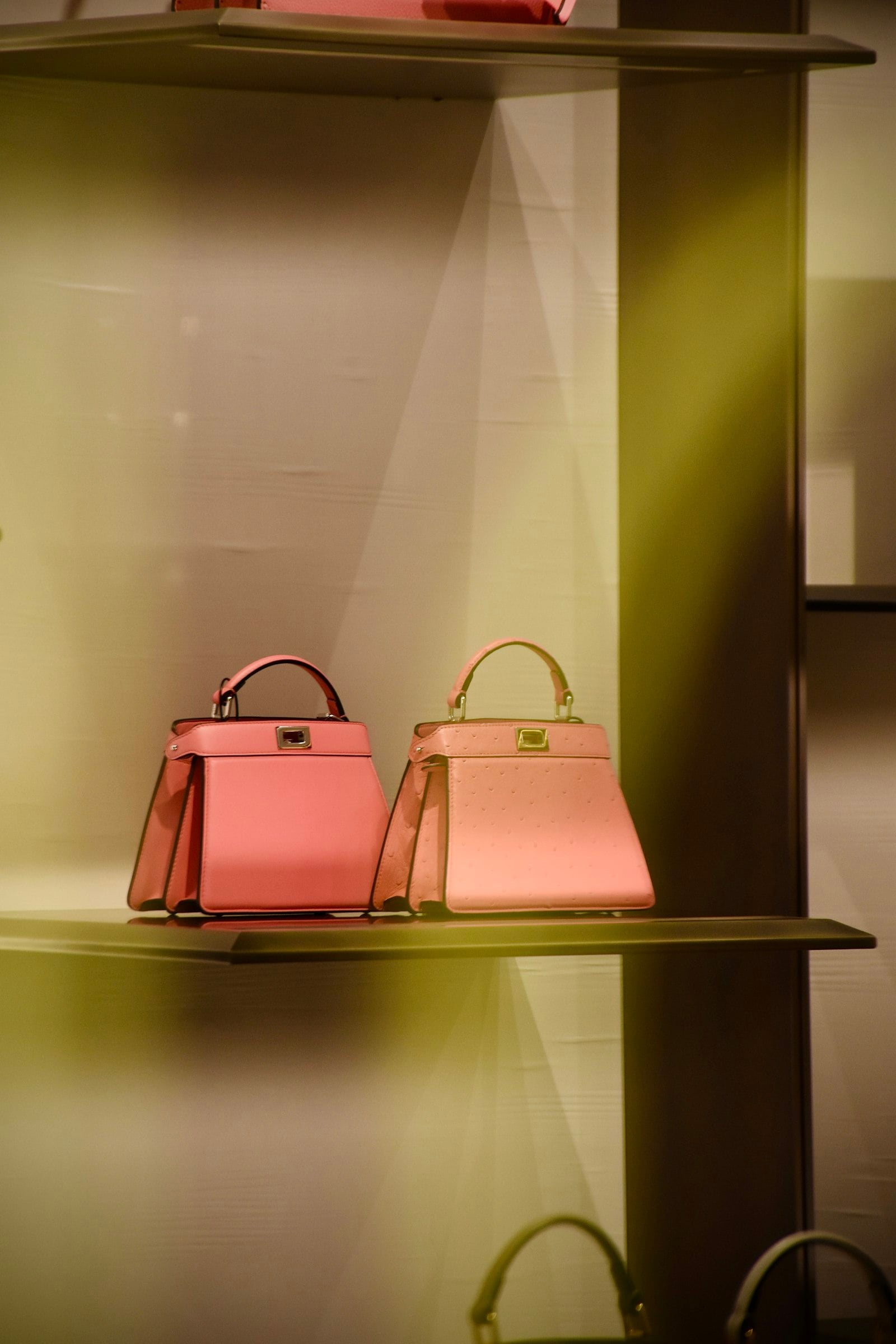 Two pink handbags on a lit shelf (photo: Arno Senoner / Unsplash)