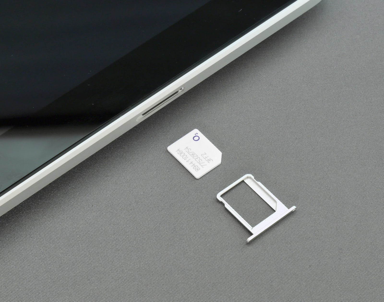 SIM card and an empty SIM tray next to a phone (photo: Brett Jordan / Unsplash)