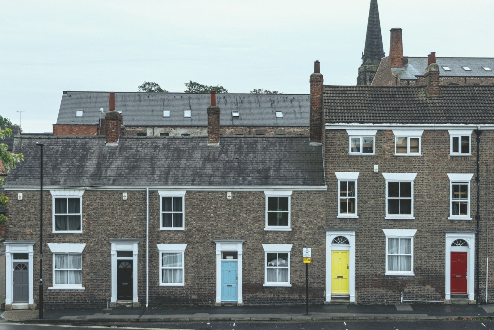 Row of brick terraced houses with colourful front doors (photo: Gonzalo Facello / Unsplash)