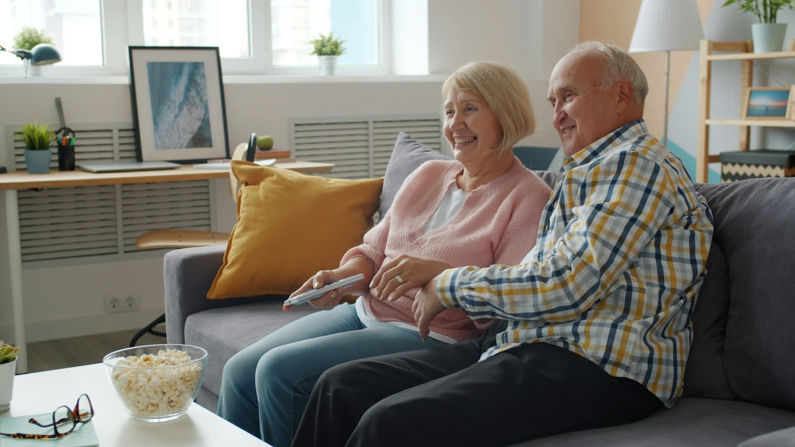 An older couple watching TV together on a sofa (photo: Vitaly Gariev / Unsplash)
