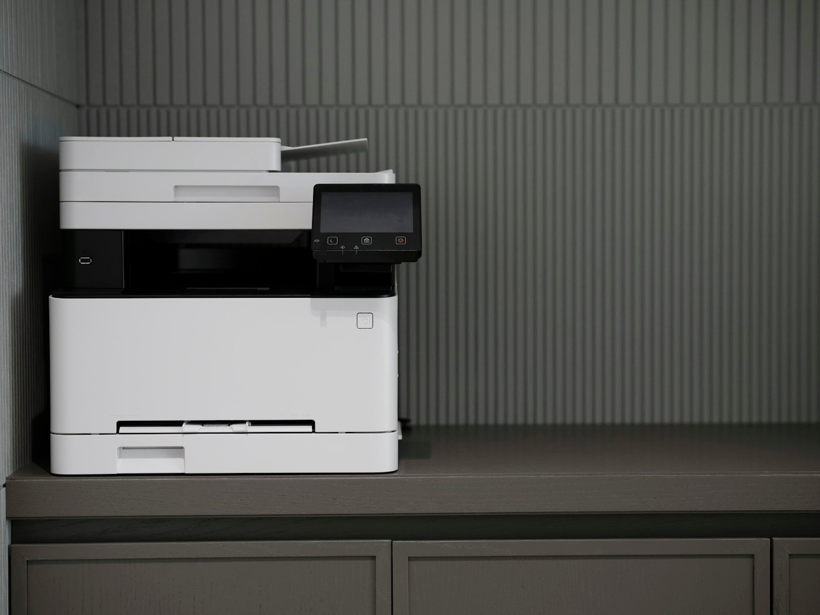 White multifunction printer on an office cabinet (photo: engin akyurt / Unsplash)