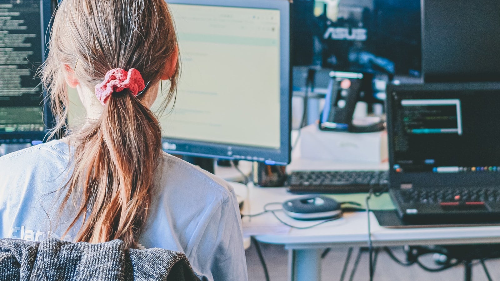 A woman working at computers in an office (photo: Compagnons / Unsplash)
